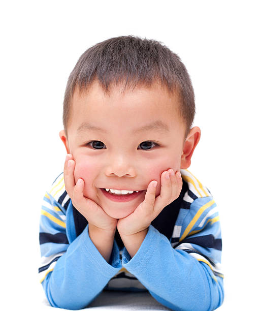 Asian boy with happy smile isolated on white background Happy Asian boy keeping his hands on the chin isolated on white background. head in hands photos stock pictures, royalty-free photos & images
