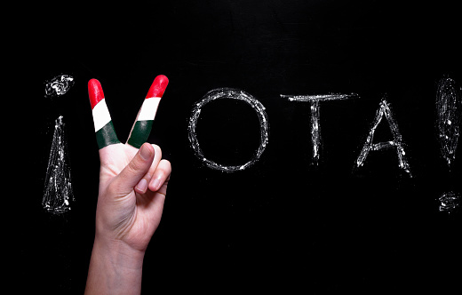 A stock photo of fingers painted in the colors of Mexico for the Hispanic and Latin vote, Vota!