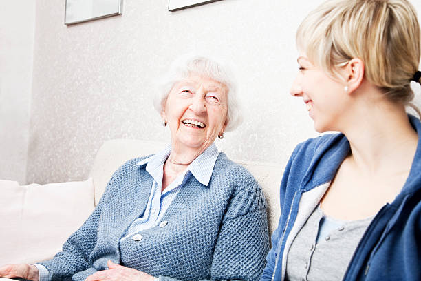 istock home caregiver talking with senior woman 155386438