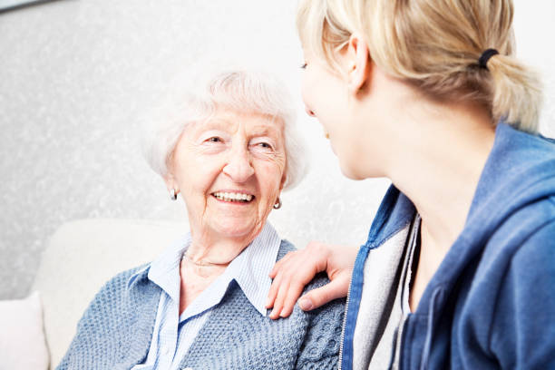 istock home caregiver talking with senior woman 155386439
