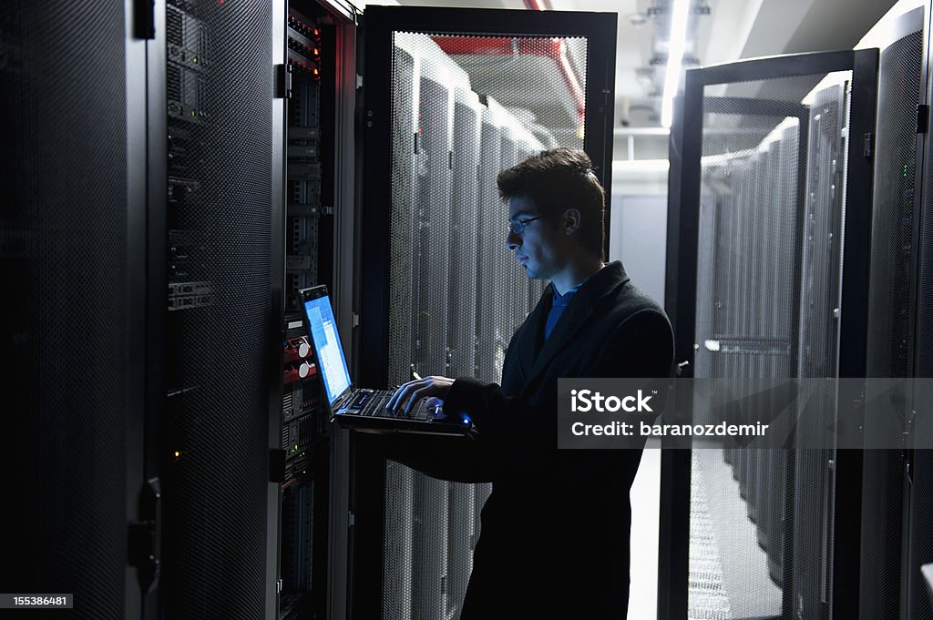 IT Programmer An IT technician programming computer equipment in a server room Network Server Stock Photo