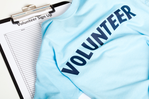 Volunteer t-shirt on a sign-up list with a clipboard.
