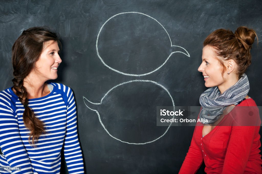 Designers in front of a blackboard  Talking Stock Photo