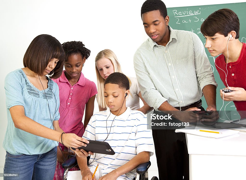 Students, teacher math class latest technology.  One in wheelchair Students, teacher in math class using latest technology.  One student in wheelchair   MORE LIKE THIS... in lightboxes below! Classroom Stock Photo