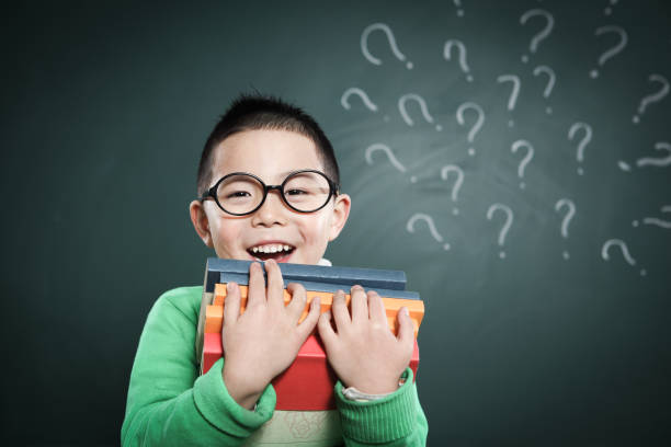 istock one boy stands in front of the blackboard 155386994