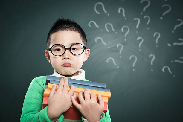 istock one boy stands in front of the blackboard 155387064