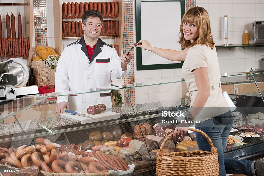 여자 taking 평하 of 소시지 in butchers 쇼핑하다 - 로열티 프리 고기 스톡 사진