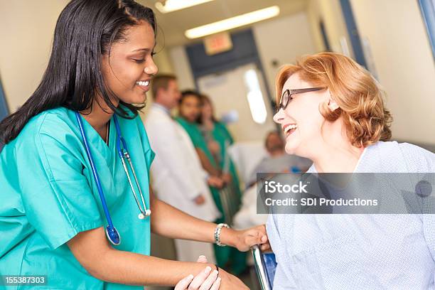 Paciente Em Cadeira De Rodas No Hospital Sendo Ajudado Pela Enfermeira Cuidar - Fotografias de stock e mais imagens de 30-39 Anos