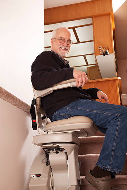 Senior using stairlift in home: Assisted Living