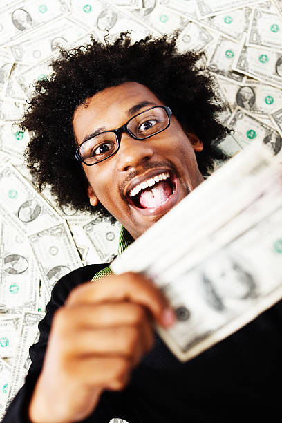 istock Delighted young man with lots of US dollars 155387460