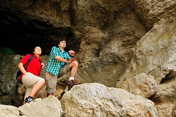 istock young couple standing at cave entrance 155387488