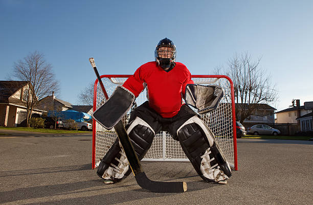 portero de hockey de bola en su red en una calle - hockey sobre ruedas fotografías e imágenes de stock