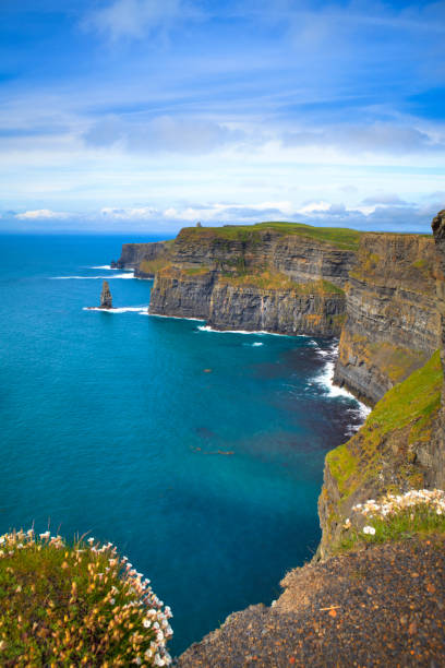 Cliffs near a mass of water in Moher, Ireland Cliffs of Moher, Ireland cliffs of moher stock pictures, royalty-free photos & images
