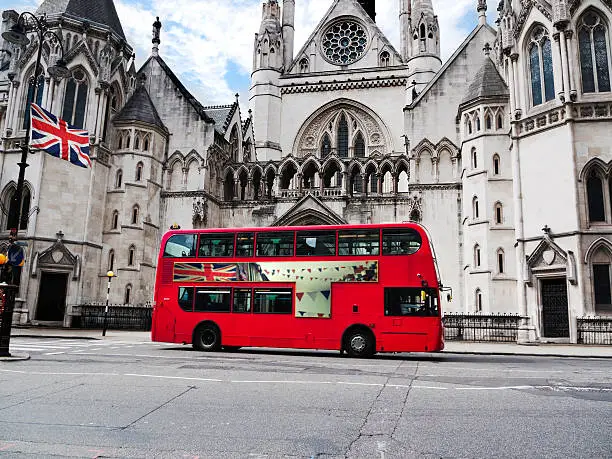 London bus with union jack flag in front of the Law Courts building. (Image on side of bus is the photographer's own).