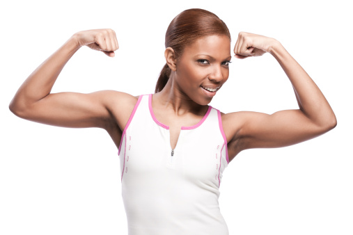 Portrait of a beautiful young african american woman playfully flexing her biceps with a coy expression on her face.