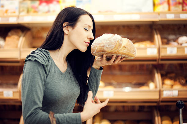 pan recién horneado - smelling bread bakery women fotografías e imágenes de stock