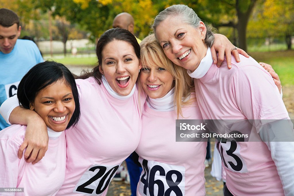 Felice gruppo di donne in rosa a un ente di beneficenza corsa - Foto stock royalty-free di Abbigliamento casual