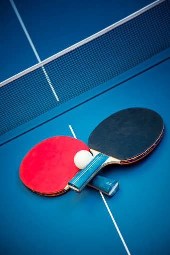 Determined young woman playing table tennis in gym