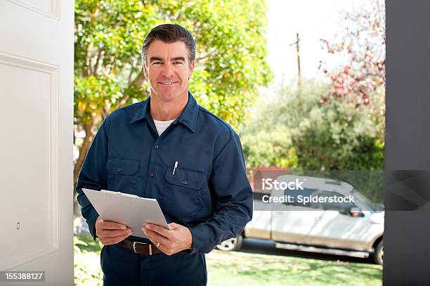 Repairman In Uniform Stock Photo - Download Image Now - Building Contractor, Clipboard, Greeting