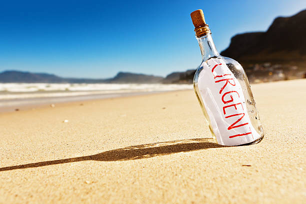 «срочно», — говорит послание в бутылке на необитаемый пляж! - message in a bottle beached bottle desert island стоковые фото и изображения