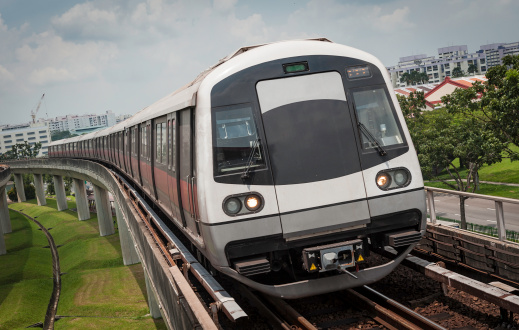 lightrail commuter train passing by city on elevated track in kuala lumpur