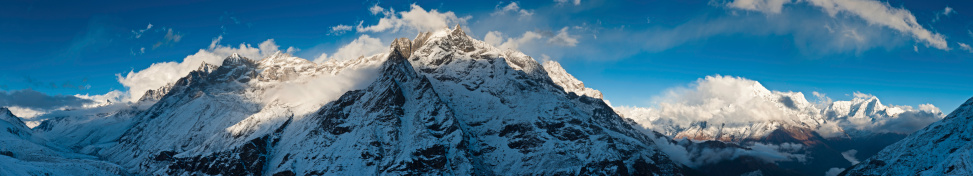 Late afternoon sunlight illuminating the snow capped peaks, dramatic rocky pinnacles and high altitude Himalaya ridges of Thamserku (6608m), Kang Tega (6779m) and Kusum Kanguru (6367m) towering over the picturesque mountain scenery of the Khumbu valley deep in the Sagarmatha National Park, Nepal. ProPhoto RGB profile for maximum color fidelity and gamut.