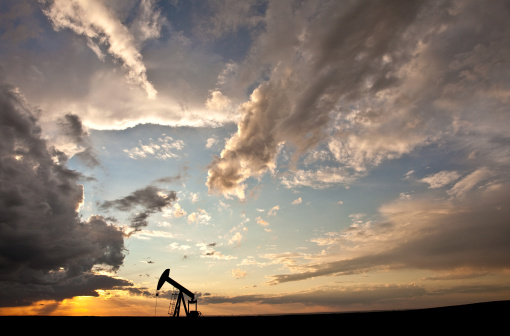 A pumpjack on the prairie. Alberta, Canada. Silhouette. Dramatic sunset sky. Copyspace. Additional themes include crude oil, pollution, environment, damage, toxic rain, oil field, industry, earth, energy, fuel, power, lever, geology, engineering, science, fossil fuel, equipment, drilling rig, well, natural gas, coal, thunderstorm, southern alberta, Calgary, weather, and hail storm. 