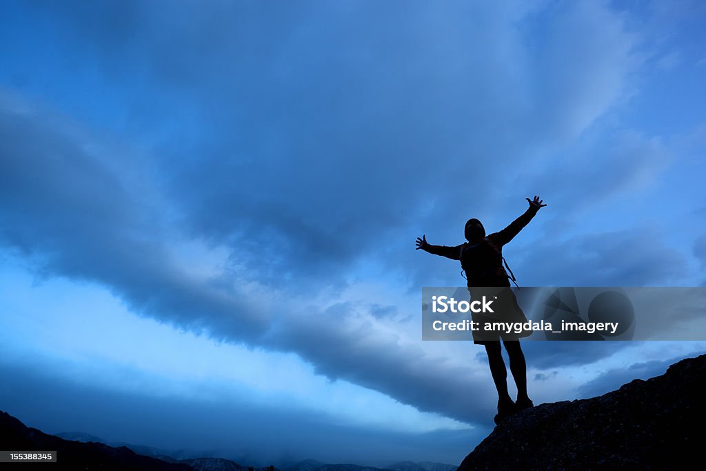 Silueta hombre alzar los brazos en cielo dramático - Foto de stock de Actividades recreativas libre de derechos