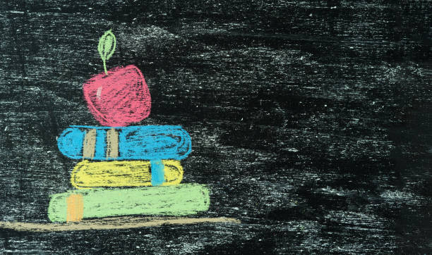 istock Black board with an apple on books hand painted with chalk. Copy space. Back to class. 1553885976