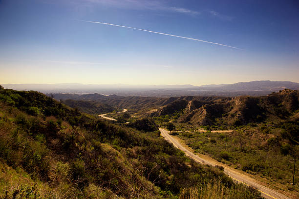 San Fernando Valley of Los Angeles, California westview View of smoggy, hazy San Fernando Valley of Los Angeles, California from north looking south toward the Santa Monica Mountains, winding street is Lopez Canyon in foreground, Pacoima, Arleta, Van Nuys, Northridge, Encino, Tarzana,Chatsworth,Porter Ranch, Woodland Hills, West Hills in background;some vingetting, polarizer used to cut glare woodland hills los angeles stock pictures, royalty-free photos & images