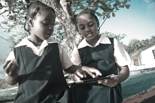 schoolgirls in uniform on digital tablet outdoors