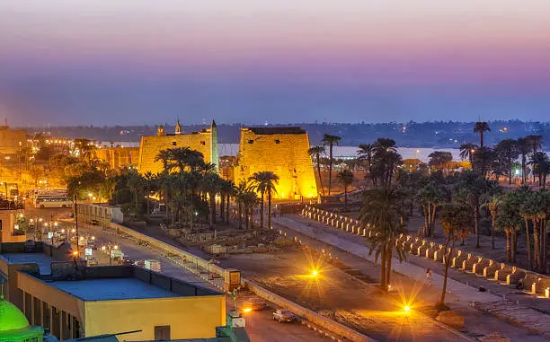 view of luxor at night - luxor temple in the center and Nile River in the background