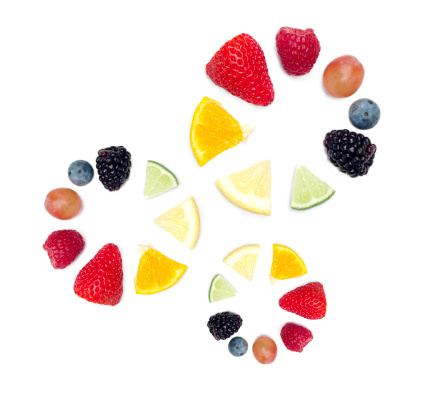 Fruits arranged in three color wheels. Includes, strawberry, raspberry, grape, blueberry, blackberry, lime, lemon, and tangerine.  Isolated on white.