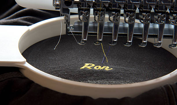 Embroidery machine Close up of a embroidery machine just finishing a nickname on a garment embroidery photos stock pictures, royalty-free photos & images