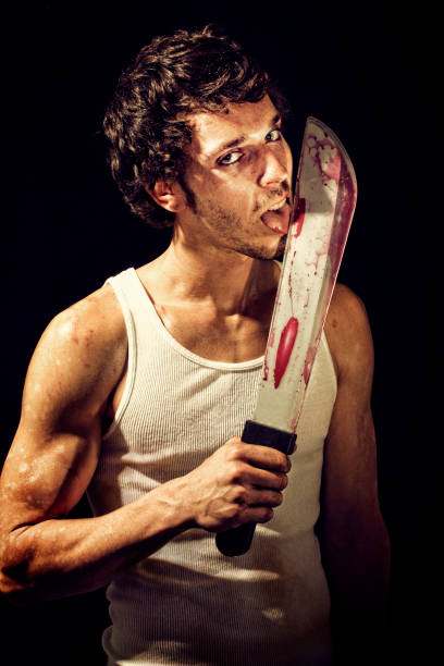 Taste for Blood Sweaty butcher man licking a big bloody knife. Toned image with noise added. Machete stock pictures, royalty-free photos & images