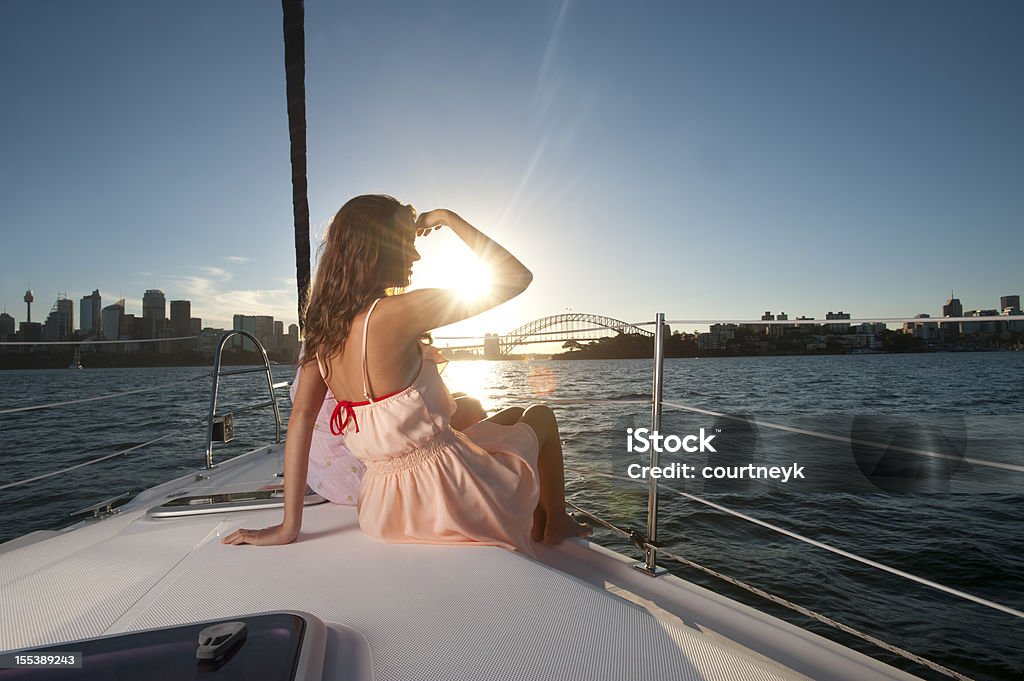 Girl looking at the horizon in a sunny day Pretty woman looking out to sea at the view of the Sydney Harbour Bridge Cruise - Vacation Stock Photo