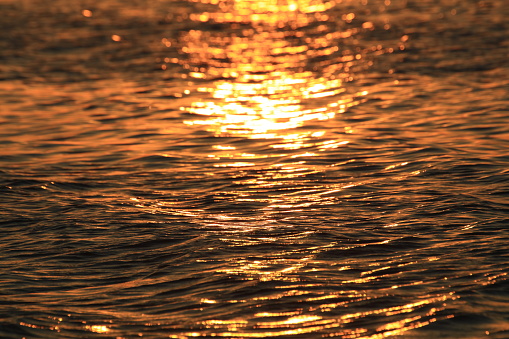 Bokeh or blur of sunlight flick reflex on the sea level natural view.