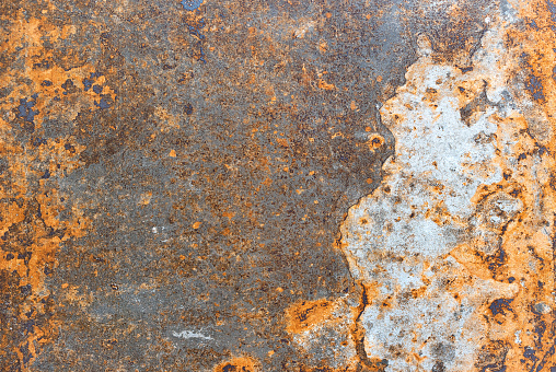 The texture of protruding rust on the surface of a metal black sheet.