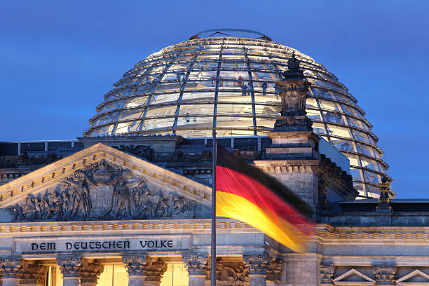 Looking up at Reichstag Dome illuminated Detail of the Reichstag in Berlin at dusk. german flag photos stock pictures, royalty-free photos & images