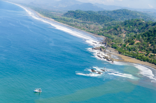 Aerial view of fishing boats near a beach along the coastline near Dominical, Costa Rica along the pacific ocean.  This area is referred to as Costa Ballena.