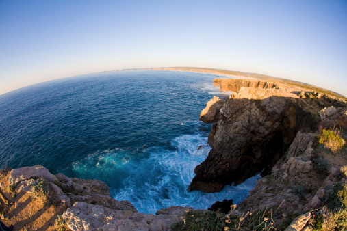 view at atlantic sea from a high cliff at western coast of Portugal (Europe) - taken with fisheye lens, so the horizon is arching and the earth seems as a globe.