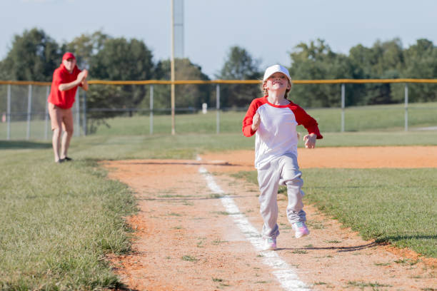 istock Cute little girl running to home base while playing t-ball 1553914254