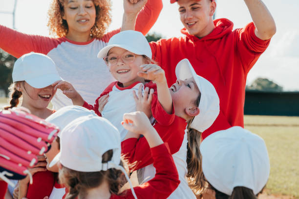istock Little league team celebrating winning baseball game together 1553914773