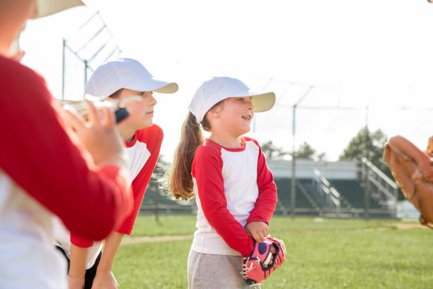 istock Little league baseball players huddle on sidelines with coach during game on field 1553914802