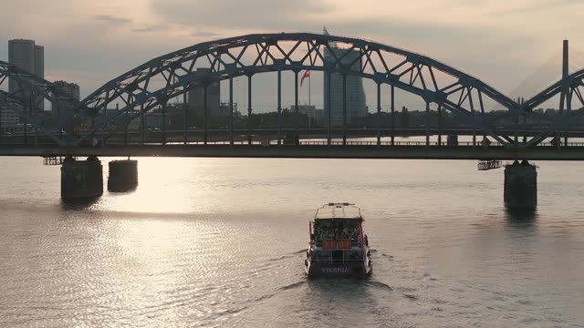 Small cruise ship or a speed boat cruising down the Daugava river in Riga