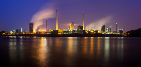 A coking plant seen over a river with a lot of steam and night blue sky. Ultra high resolution double row panorama.