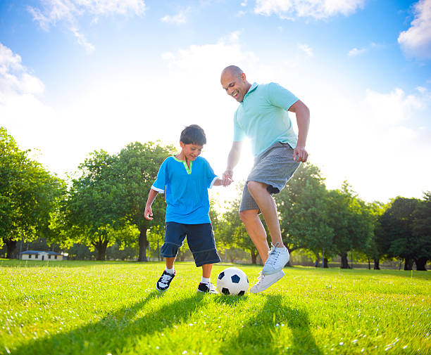 istock Father and son playing football together 155392114