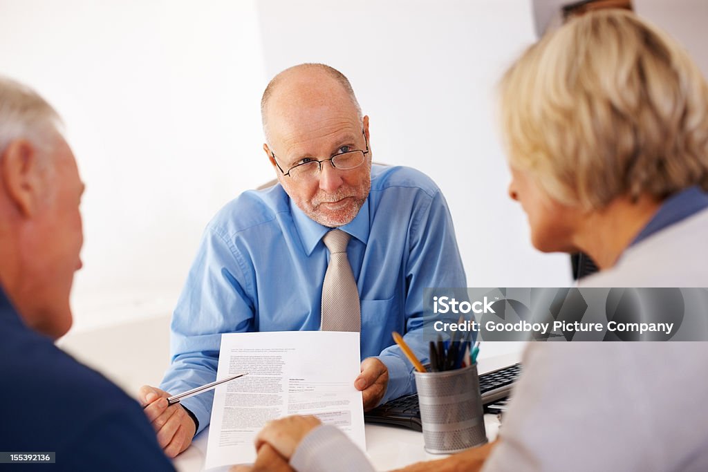 Consulente finanziario che mostrano un modulo a Coppia senior - Foto stock royalty-free di Accordo d'intesa