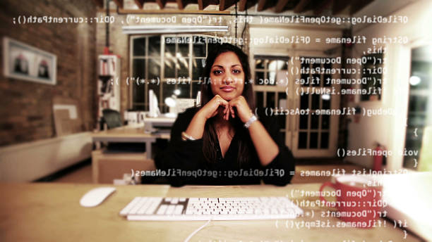 Computer programmer happy with her work Wide angle portrait of a content computer programmer sitting at her desk happy with the work she's produced.  Camera takes on the point of view of her monitor overlaid with code. extensible markup language photos stock pictures, royalty-free photos & images