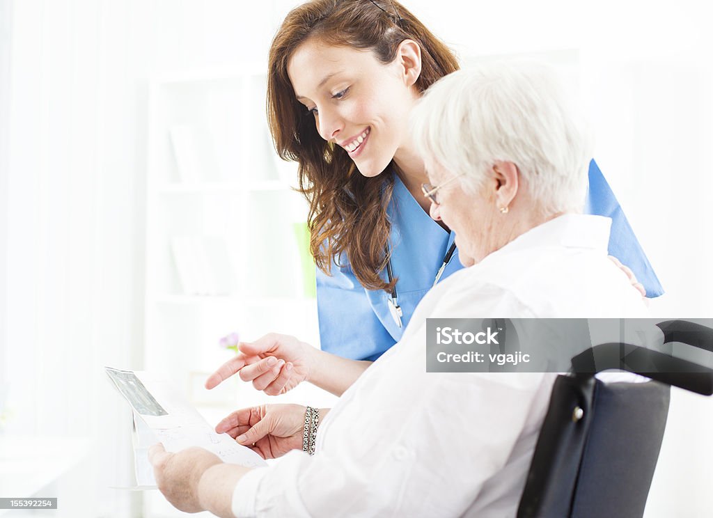 Médico explicando una ecografía imagen a mayor paciente. - Foto de stock de Tercera edad libre de derechos